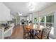 Bright kitchen with white cabinetry, stainless steel appliances, and a dining area with large windows overlooking the backyard at 1130 S Rudder Rd, Cumming, GA 30041