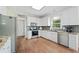 Bright kitchen with white cabinetry, granite countertops, stainless steel appliances, and hardwood flooring at 1130 S Rudder Rd, Cumming, GA 30041