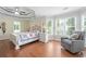 Large main bedroom with tray ceiling, hardwood floors, and many windows allowing natural light to fill the room at 1130 S Rudder Rd, Cumming, GA 30041
