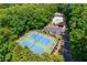 Aerial view of tennis courts and swimming pool surrounded by lush green trees at 1130 S Rudder Rd, Cumming, GA 30041