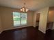A bright dining room featuring a chandelier and a large window overlooking the landscaped front yard at 120 Squirrel Way, Atlanta, GA 30349