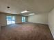 Spacious living room featuring new carpeting and sliding doors to the outdoor area and parked car at 120 Squirrel Way, Atlanta, GA 30349