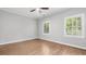 Bright bedroom featuring hardwood floors, neutral paint, crown molding, and natural light from two windows at 3532 Paces Nw Pl, Atlanta, GA 30327