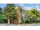 Corner view of the brick home with surrounding mature trees and landscaping and black window shutters at 3532 Paces Nw Pl, Atlanta, GA 30327