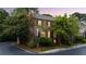 Brick home exterior with well-maintained landscaping, black shutters, and a mature tree at sunset at 3532 Paces Nw Pl, Atlanta, GA 30327