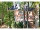 Brick home featuring a spacious deck with seating amid beautiful mature trees at 5040 Harrington Rd, Johns Creek, GA 30022