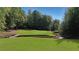 Lush backyard with a well-maintained golf lawn and a small creek, providing a serene and picturesque setting at 5040 Harrington Rd, Johns Creek, GA 30022