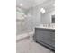 Contemporary bathroom with a sleek gray vanity, marble-look tile shower, and stylish lighting fixtures at 5040 Harrington Rd, Johns Creek, GA 30022