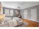 Bright bedroom showcasing hardwood floors, neutral tones, and great natural light from the windows with white shutters at 5040 Harrington Rd, Johns Creek, GA 30022