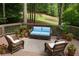 Inviting outdoor deck featuring wicker furniture, potted plants, and a serene view of the surrounding trees at 5040 Harrington Rd, Johns Creek, GA 30022