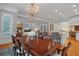 Elegant dining room featuring a chandelier, hardwood floors, and open layout to the kitchen and living area at 5040 Harrington Rd, Johns Creek, GA 30022