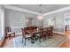 Formal dining room featuring hardwood floors, decorative chandelier, and ample seating for elegant dinner parties at 5040 Harrington Rd, Johns Creek, GA 30022