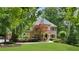 Charming two-story brick home with a manicured lawn, mature trees and professionally landscaped front yard at 5040 Harrington Rd, Johns Creek, GA 30022