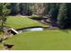 Scenic view of the lush green golf course with a water hazard and bridge at 5040 Harrington Rd, Johns Creek, GA 30022