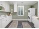 Well-lit laundry room includes a front-load washer and dryer, cabinetry, and sink at 5040 Harrington Rd, Johns Creek, GA 30022