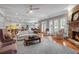 Bright and airy living room with a stone fireplace, hardwood floors, and an open layout to the kitchen at 5040 Harrington Rd, Johns Creek, GA 30022