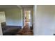 Hallway featuring neutral paint, durable wood-look flooring and views into the living room and kitchen at 3656 Salem Trl, Lithonia, GA 30038