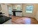 Galley kitchen features wood-look floors, black counters, white cabinets, and a stainless steel sink at 3656 Salem Trl, Lithonia, GA 30038