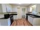 Kitchen features white cabinets, dark countertops, modern appliances, and wood-look flooring at 3656 Salem Trl, Lithonia, GA 30038