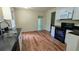 Kitchen featuring black countertops, white cabinets and durable wood-look flooring at 3656 Salem Trl, Lithonia, GA 30038
