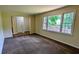 Spacious living room with new carpet, neutral paint and view of the brick privacy wall from a large window at 3656 Salem Trl, Lithonia, GA 30038