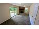 Living room with a brick fireplace, carpet flooring, a sliding door to the patio, and neutral walls at 3656 Salem Trl, Lithonia, GA 30038