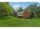 Exterior rear view of brick home shows a walkout basement, deck, lawn, and mature trees at 4200 E Highway 166 Rd, Carrollton, GA 30116
