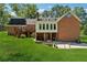 Rear elevation of a brick home displays a well-maintained lawn, deck, and full walkout basement at 4200 E Highway 166 Rd, Carrollton, GA 30116
