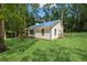 Charming single-story home with a blue metal roof nestled among mature trees and a lush green lawn at 4200 E Highway 166 Rd, Carrollton, GA 30116