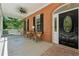 Covered brick front porch with black door, ceiling fan and sitting area with swing at 4200 E Highway 166 Rd, Carrollton, GA 30116