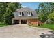 Rear exterior showing the garage and parking area along with the large front yard and a forested backdrop at 4200 E Highway 166 Rd, Carrollton, GA 30116