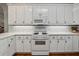 Bright kitchen featuring white cabinets, tile backsplash, and modern appliances at 4200 E Highway 166 Rd, Carrollton, GA 30116