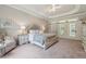 Elegant primary bedroom boasts a tray ceiling, stylish furniture, and natural light at 4200 E Highway 166 Rd, Carrollton, GA 30116