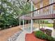 A house with an elevated deck overlooking a patio and yard with mature trees, offering a private outdoor space at 6765 Crofton Dr, Alpharetta, GA 30005