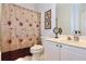 Bright bathroom with a floral shower curtain, white vanity, and decorative accents at 6765 Crofton Dr, Alpharetta, GA 30005