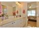 Bathroom featuring double sinks, a mirror, and view into a bedroom at 6765 Crofton Dr, Alpharetta, GA 30005