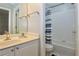 Bright bathroom with white cabinets, granite counters, and tiled shower with blue and white curtain at 6765 Crofton Dr, Alpharetta, GA 30005