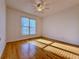 Cozy bedroom with hardwood floors, a ceiling fan, and natural light streaming through the window at 6765 Crofton Dr, Alpharetta, GA 30005