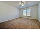 Carpeted bedroom with ceiling fan and window allowing natural light at 6765 Crofton Dr, Alpharetta, GA 30005