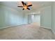 Spacious bedroom featuring neutral carpeting, ceiling fan, and an ensuite entrance to the bathroom area at 6765 Crofton Dr, Alpharetta, GA 30005