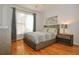 Well-lit bedroom featuring a large window, hardwood floors, and stylish furnishings at 6765 Crofton Dr, Alpharetta, GA 30005