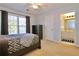 Well-lit bedroom with a dark wood bed frame, dresser, and bathroom view at 6765 Crofton Dr, Alpharetta, GA 30005