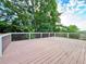 Large wooden deck with white railings, surrounded by lush greenery, perfect for outdoor relaxation and entertaining at 6765 Crofton Dr, Alpharetta, GA 30005