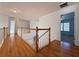 Upstairs hallway with hardwood flooring and wood railing at 6765 Crofton Dr, Alpharetta, GA 30005