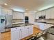 Modern kitchen featuring stainless steel appliances, black granite countertops, and custom white cabinets at 6765 Crofton Dr, Alpharetta, GA 30005