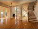 Bright open-concept living room with hardwood floors, fireplace, and staircase to second floor at 6765 Crofton Dr, Alpharetta, GA 30005