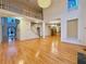 Open living area with hardwood floors, high ceilings, and a grand chandelier with staircase at 6765 Crofton Dr, Alpharetta, GA 30005