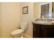 Stylish powder room with a granite countertop and dark wood cabinets at 6765 Crofton Dr, Alpharetta, GA 30005