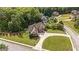 Aerial view showcases lush yard of a home with a circular driveway, nestled in mature trees at 9742 Fallview Ct, Villa Rica, GA 30180