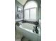 Bathroom featuring a soaking tub with chrome fixtures beneath a large arched window at 9742 Fallview Ct, Villa Rica, GA 30180